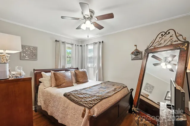 a bedroom with a bed and a flat tv screen on the dresser
