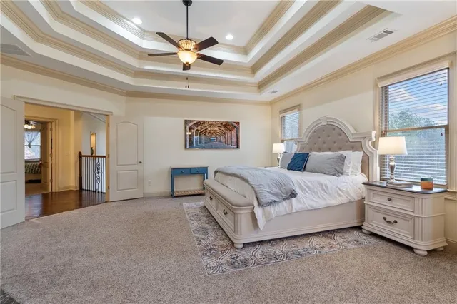 a spacious bedroom with a bed a ceiling fan and a walk in closet