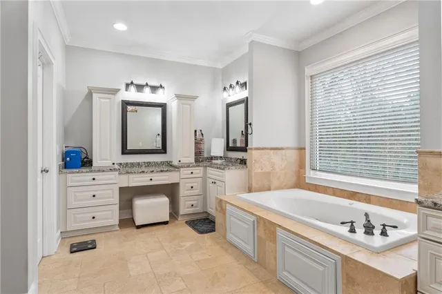 a spacious bathroom with a granite countertop tub sink and mirror