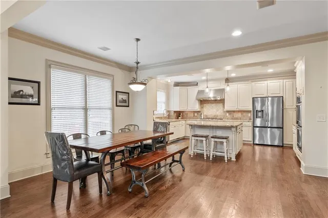 a dining room with a wooden table and chairs