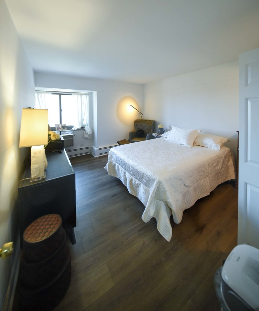 7337 South South Shore Drive, Unit 708 Chicago, IL 60649 - Photo 11 of 14 a spacious bedroom with a bed and window