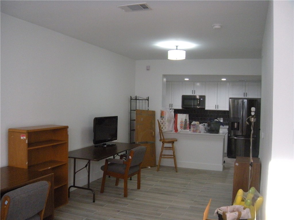 2529 Rio Grande Street, Unit 79 Austin, TX 78705 - Photo 4 of 13 a living room with furniture kitchen view and a flat screen tv