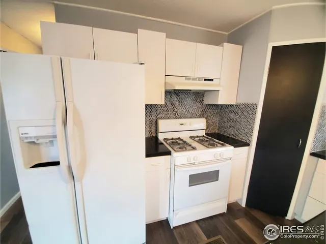 a kitchen with a refrigerator a stove and a sink