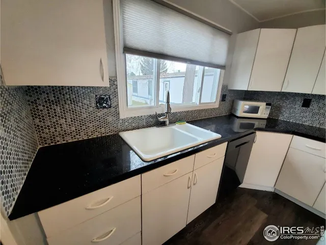 a kitchen with granite countertop a sink and a stove
