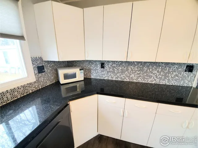 a kitchen with a white cabinets sink and dishwasher