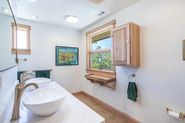a bedroom with a bed and a dresser next to a window