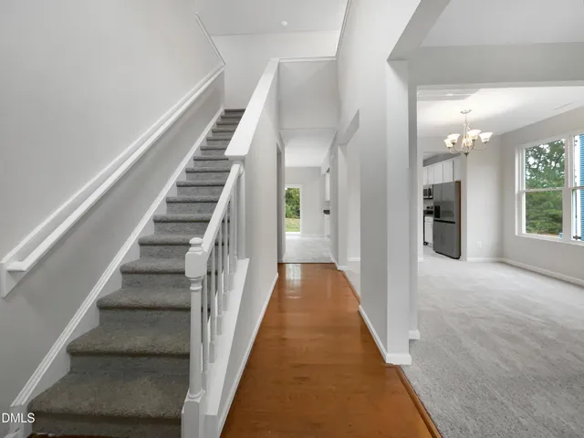 a view of a hallway with wooden floor and entryway