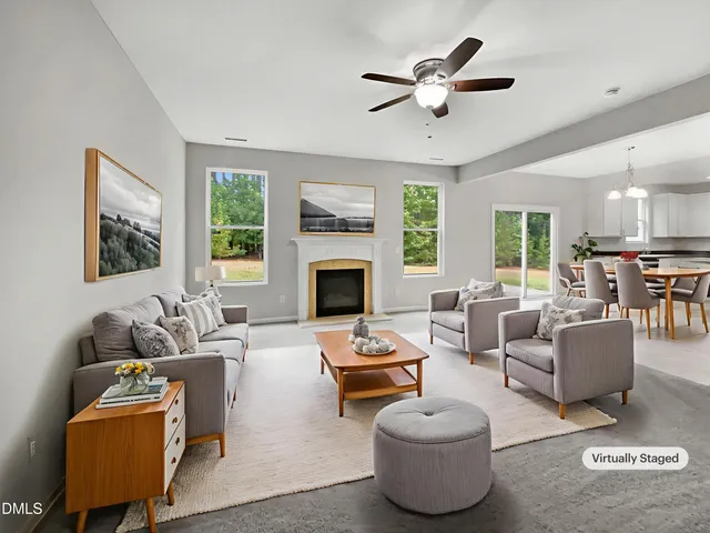 a living room with furniture a fireplace and a large window