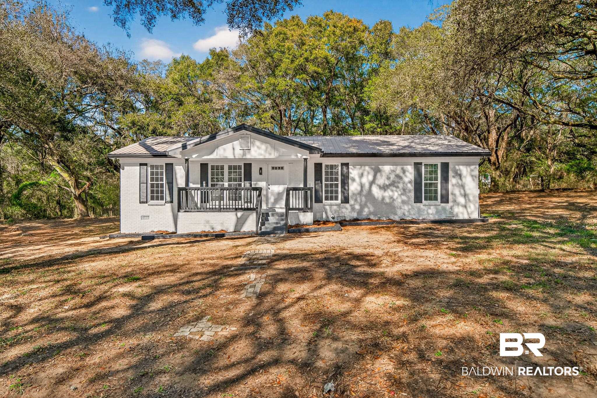 10650 Old Pascagoula Road Theodore, AL 36582 - Photo 1 of 77 Single story home with a porch, view of scattered trees, and brick siding