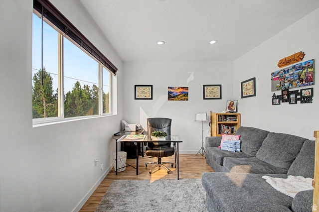 12645 East Cedar Ridge Drive Fairview, UT 84629 - Photo 6 of 34 Bright interior space featuring a wide window with outdoor tree scenery, recessed ceiling lighting, and wood-finish flooring