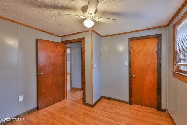 a view of empty room with window and ceiling fan
