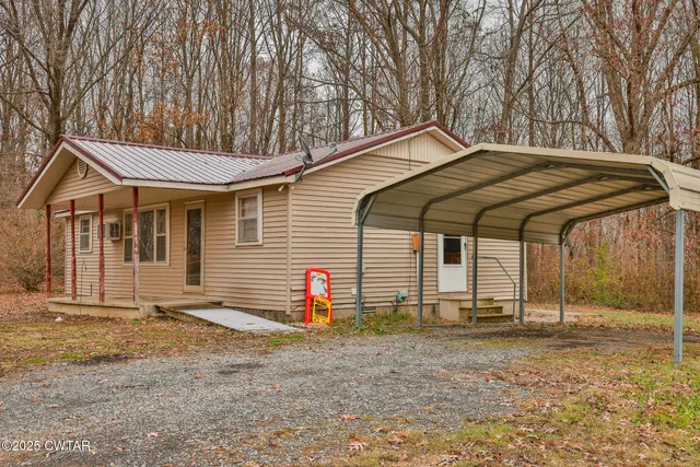 a backyard of a house with barbeque oven table and chairs