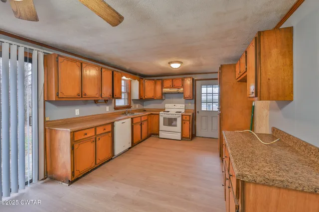 a kitchen with stainless steel appliances granite countertop wooden cabinets a sink and a stove