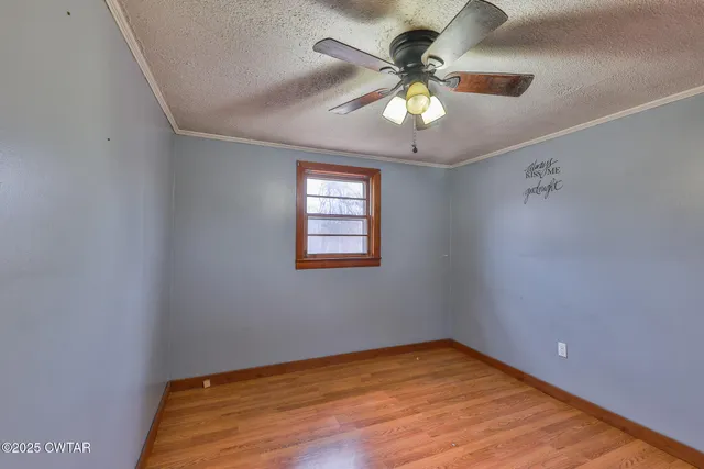 an empty room with a window and a ceiling fan