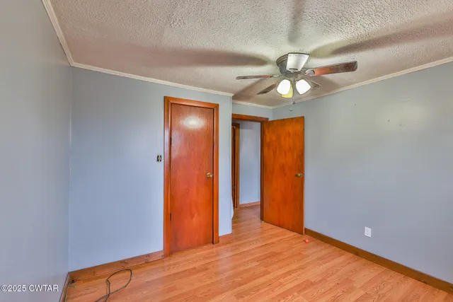 a bedroom with a bed and a chandelier fan