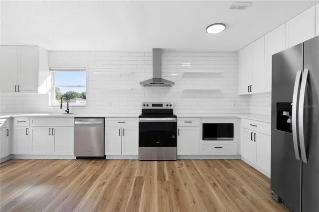 a kitchen with a refrigerator and a stove top oven