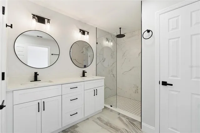 a bathroom with a double vanity sink mirror and shower