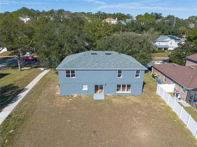 an aerial view of a house next to a yard