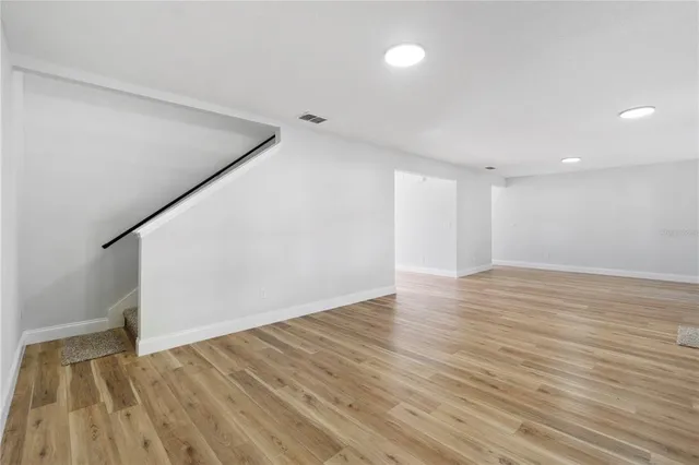 a view of an empty room with wooden floor