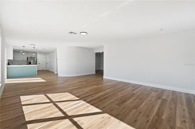 a view of a room with wooden floor and a window