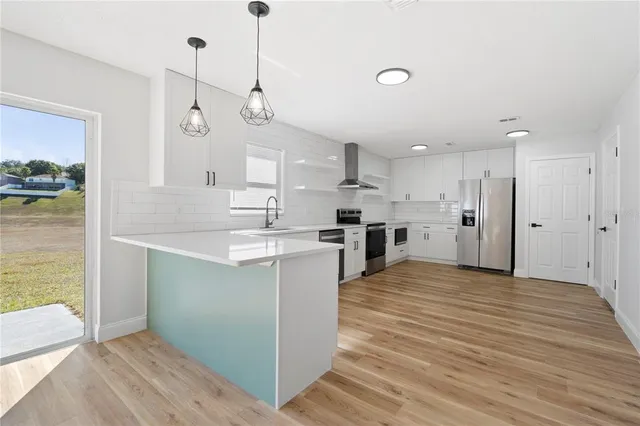 a large kitchen with a refrigerator a stove and a sink