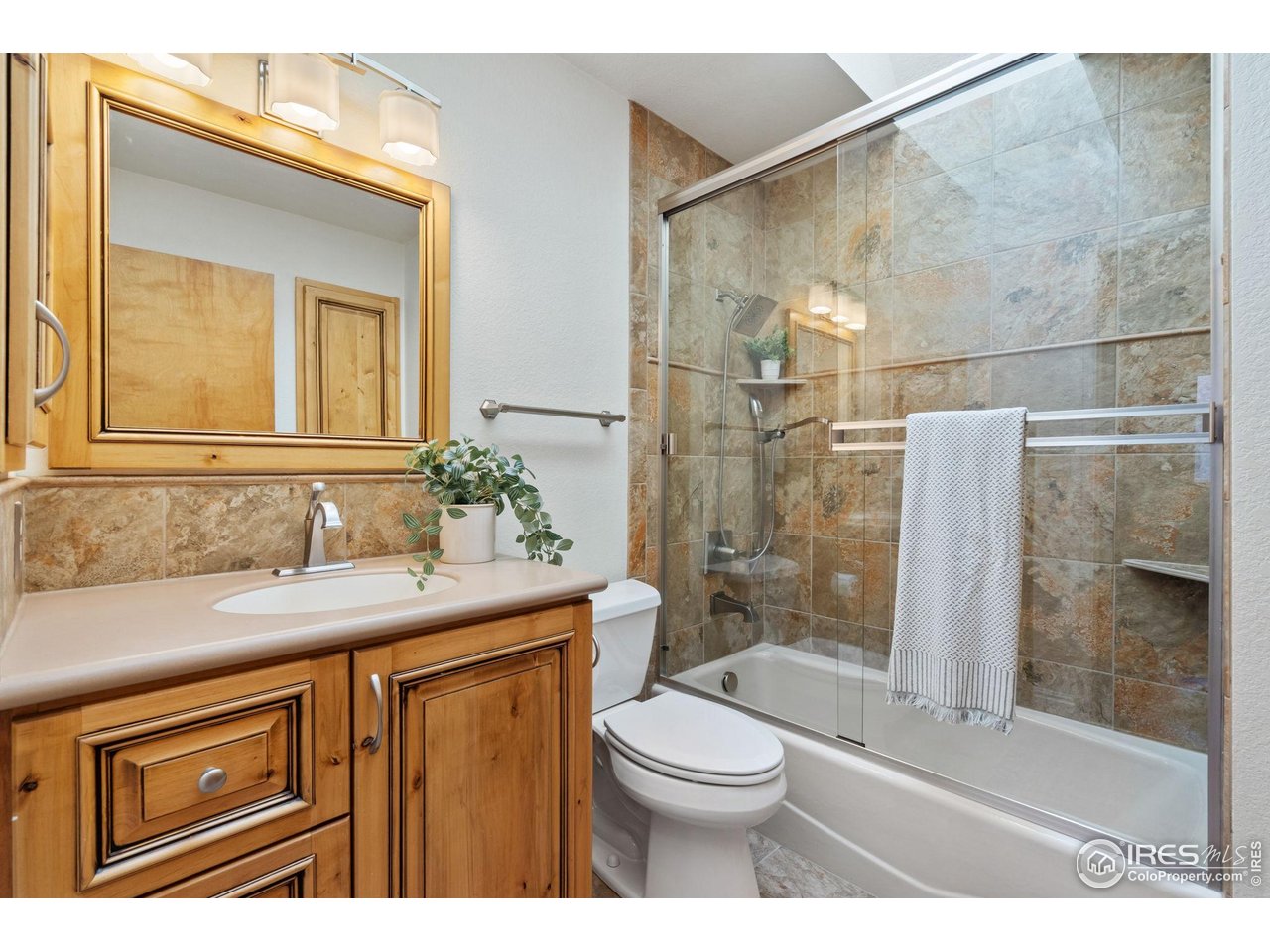 4331 West 16th Street Road Greeley, CO 80634 - Photo 17 of 41 Main Floor Second Bathroom Updated with Custom Cabinets, Tile & Glass Tub Surround