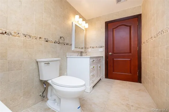 a bathroom with a toilet a sink and mirror