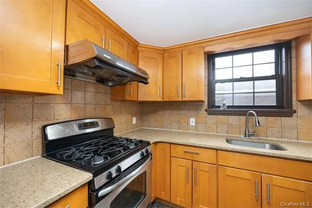 a kitchen with stainless steel appliances granite countertop a sink a stove and cabinets