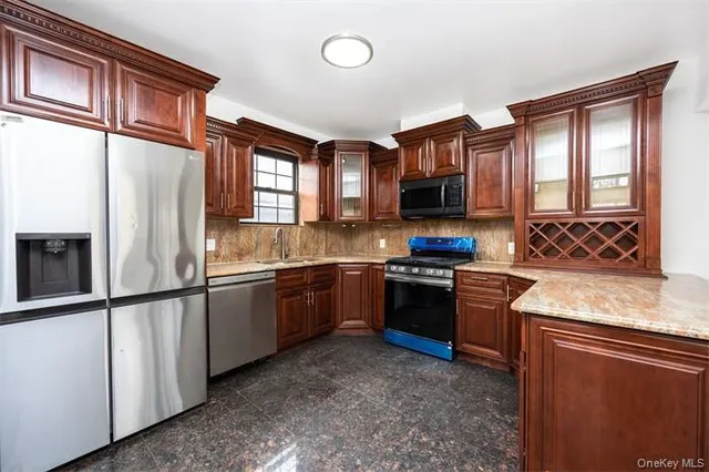 a kitchen with stainless steel appliances granite countertop a stove a sink and a refrigerator