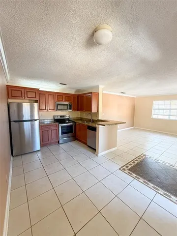 a kitchen with stainless steel appliances granite countertop a refrigerator and a stove top oven