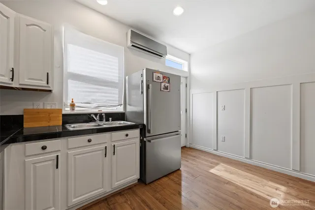 a kitchen with granite countertop a sink and white cabinets