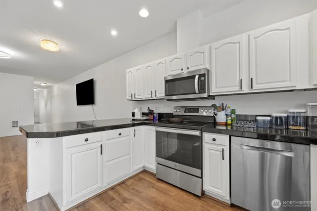 a kitchen with stove cabinets and wooden floor