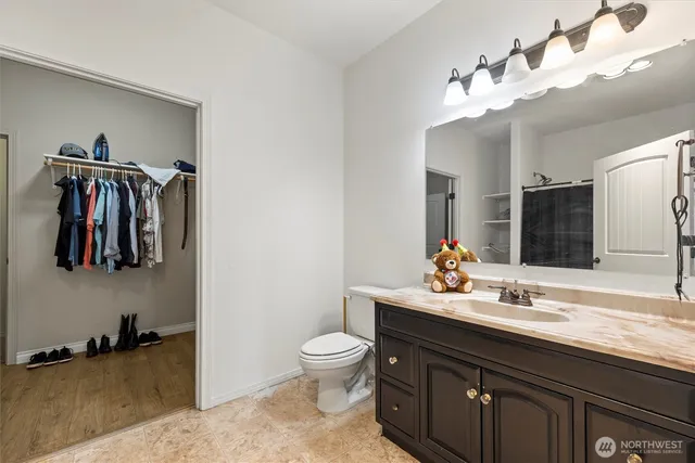 an empty room with wooden floor ceiling fan and windows