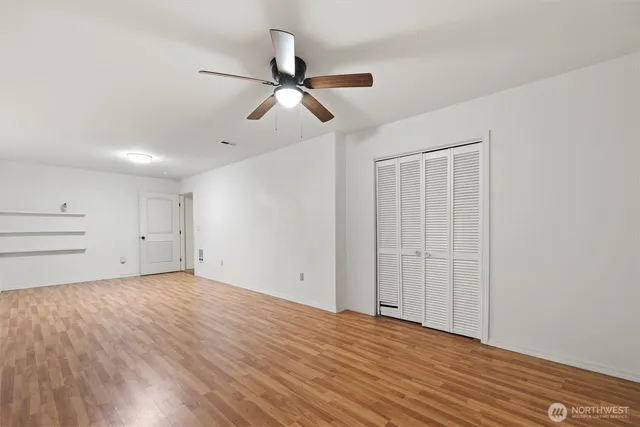 an empty room with windows and closet