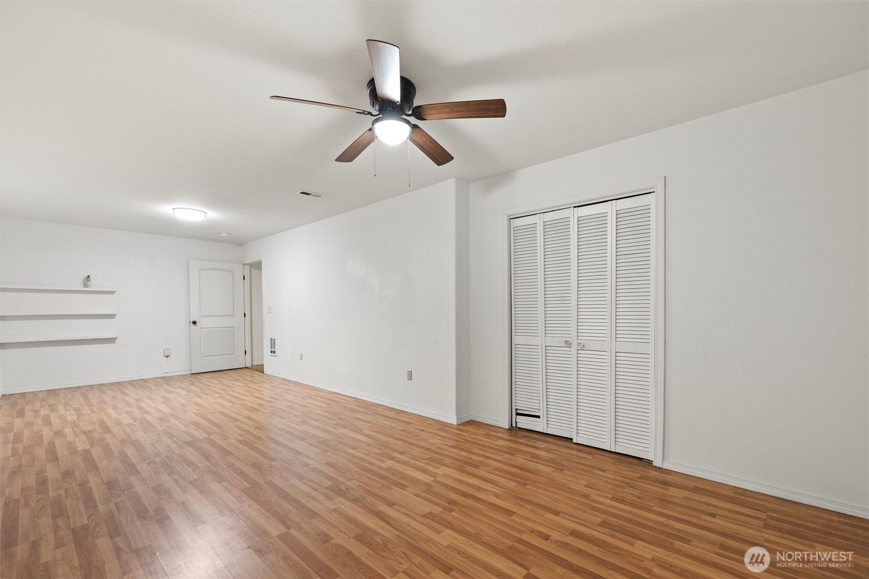 149 South Tweedt Place Kennewick, WA 99336 - Photo 8 of 18 an empty room with wooden floor ceiling fan and windows