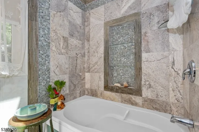 a white bath tub sitting next to a toilet