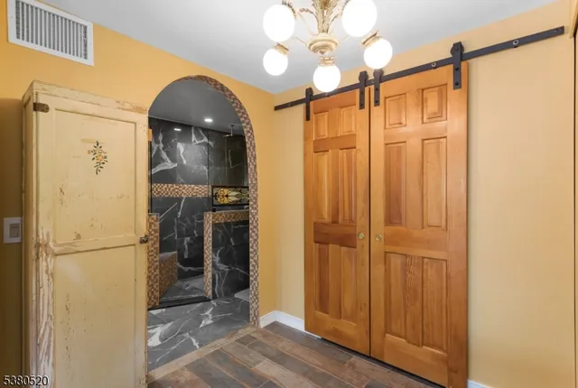a view of a hallway with wooden floor and a kitchen