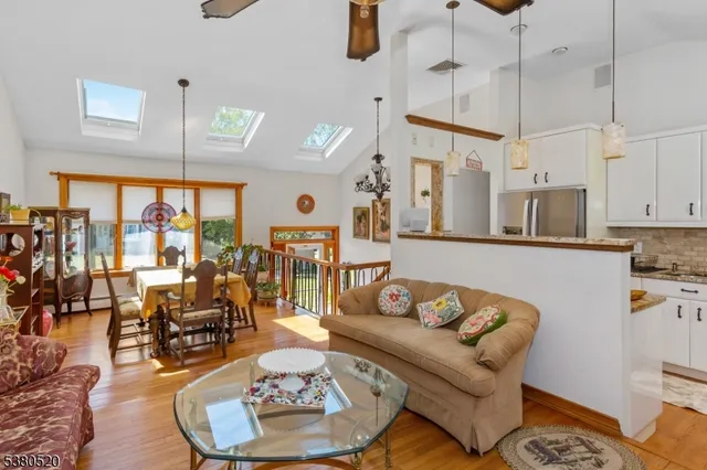 a living room with furniture kitchen view and a wooden floor