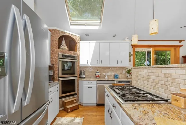 a kitchen with stainless steel appliances granite countertop a stove a sink and a refrigerator