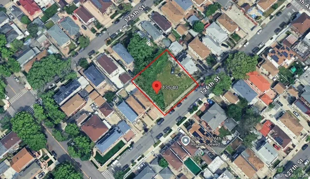 an aerial view of residential houses with green space