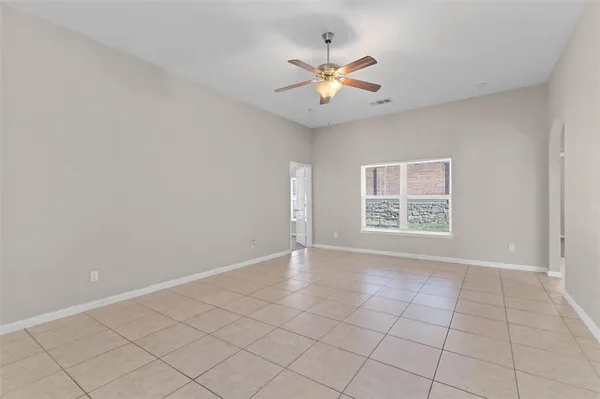 an empty room with windows and fan