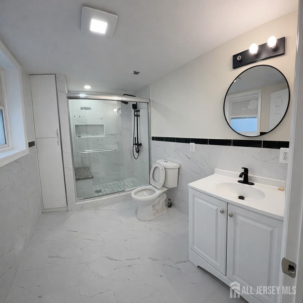 30 Falmouth Road Iselin, NJ 08830 - Photo 17 of 23 a bathroom with a sink a toilet and a mirror
