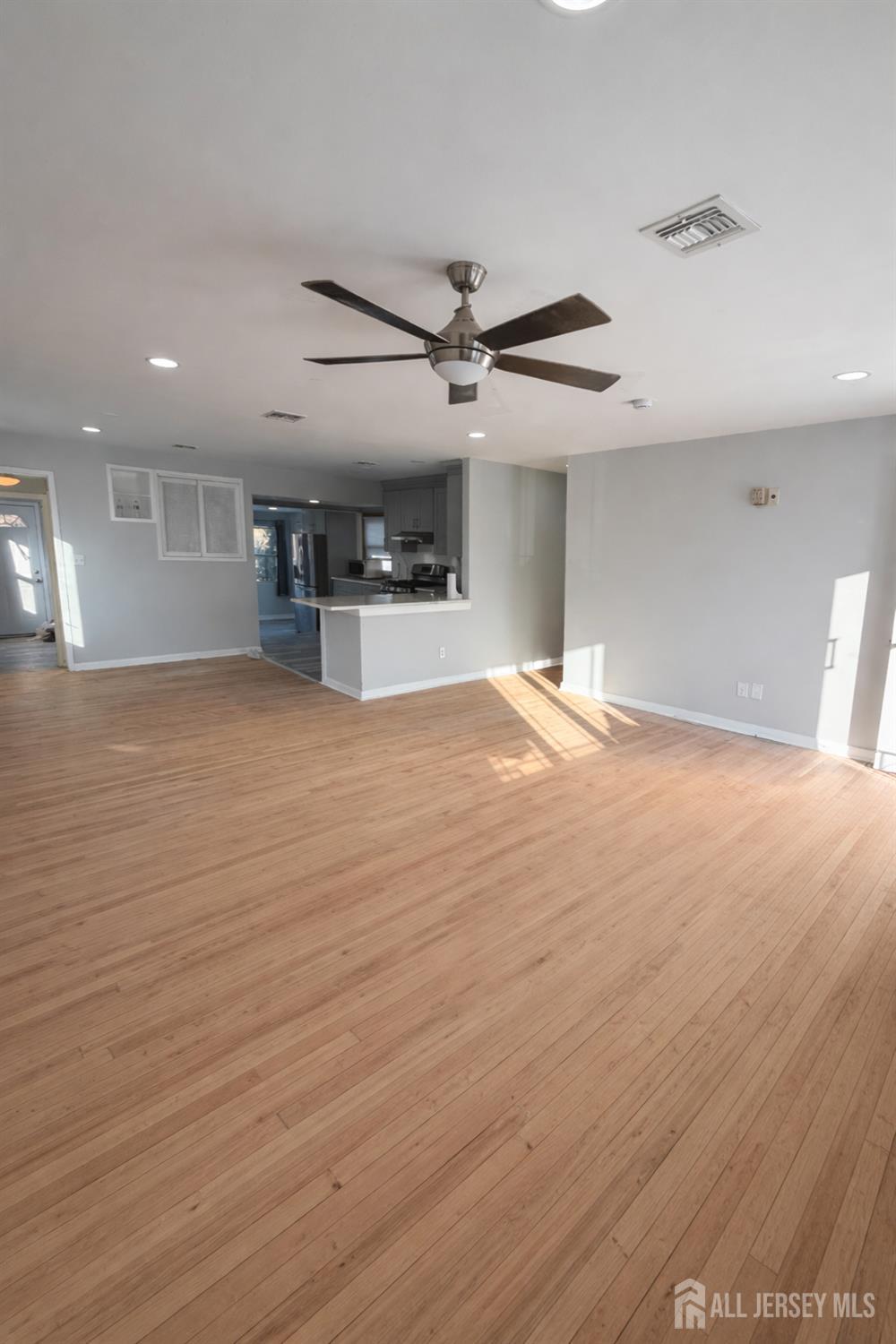 30 Falmouth Road Iselin, NJ 08830 - Photo 6 of 23 an empty room with wooden floor ceiling fan and windows