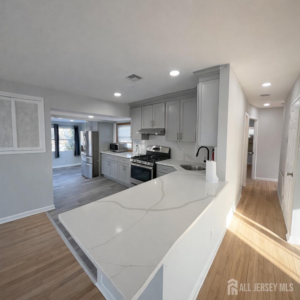 30 Falmouth Road Iselin, NJ 08830 - Photo 8 of 23 a large white kitchen with lots of counter top space a refrigerator and a sink