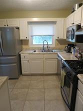 3760 Cedar Hurst Way Atlanta, GA 30349 - Photo 3 of 22 a kitchen with stainless steel appliances granite countertop a sink and a stove