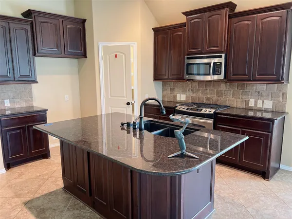 a kitchen with granite countertop a sink and a stove