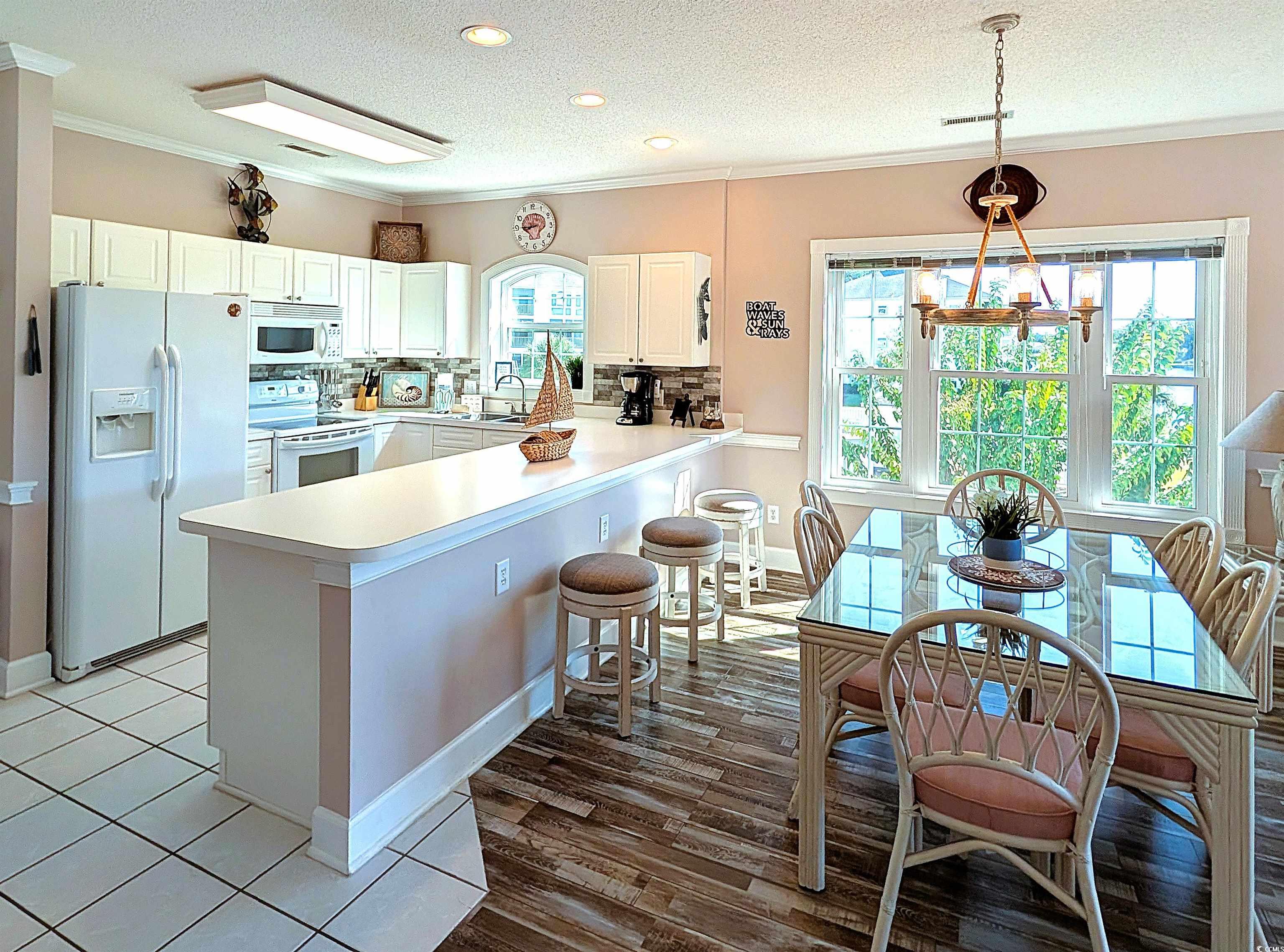 1512 Lanterns Rest Road, Unit 201 Myrtle Beach, SC 29579 - Photo 2 of 23 Kitchen with decorative backsplash, white appliances, a textured ceiling, ornamental molding, and a peninsula
