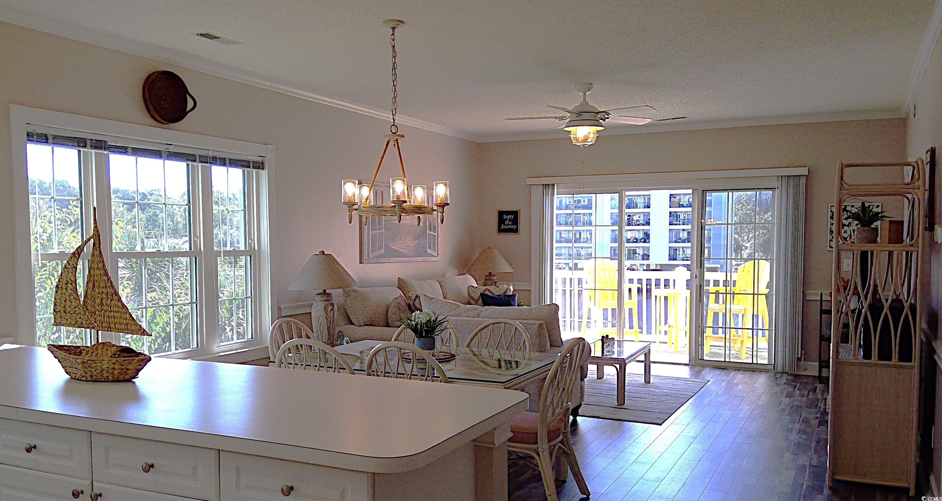 1512 Lanterns Rest Road, Unit 201 Myrtle Beach, SC 29579 - Photo 4 of 23 Dining room with crown molding, healthy amount of natural light, dark wood finished floors, a ceiling fan, and a chandelier