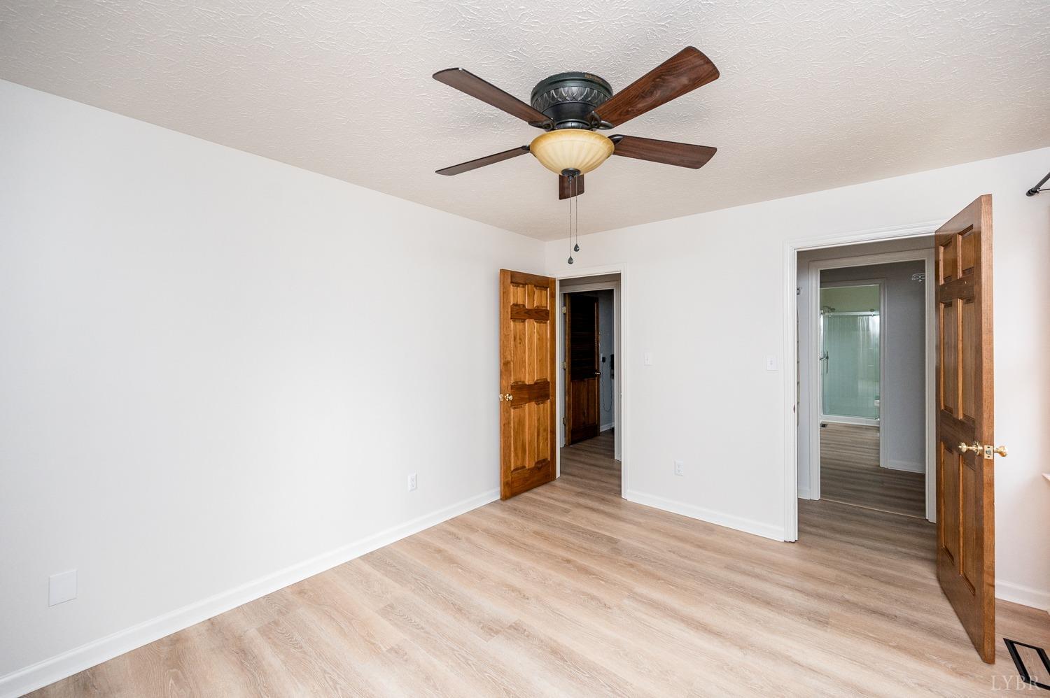 3039 Crockett Road Goode, VA 24556 - Photo 22 of 55 a view of a big room with wooden floor and a ceiling fan