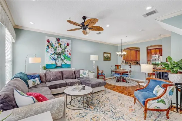 a living room with furniture kitchen view and a window